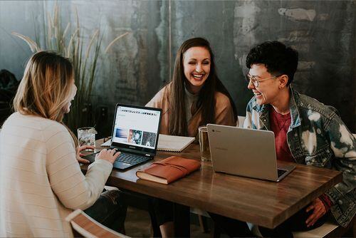 Group of people working at table of their laptop devices